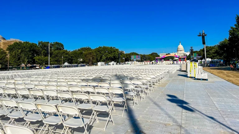 Large outdoor event setup with rows of chairs, crowd control barriers, and flooring, ideal for festivals, outdoor gatherings, or public events.