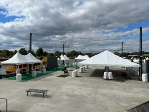 Large frame tent illuminated with LED lights, providing an elegant outdoor event venue. Chairs and tables are neatly arranged for guests to enjoy.