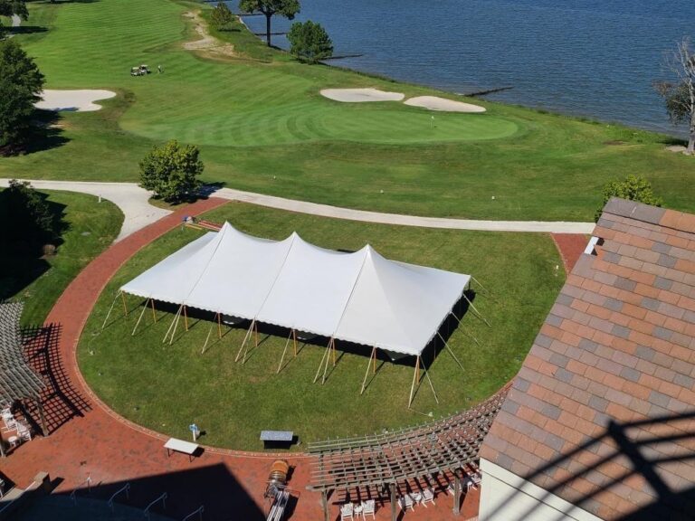 A well-organized event site with a structure tent providing coverage for guests. Surrounding fencing for crowd control, bike racks, and other event amenities are in place for the occasion.
