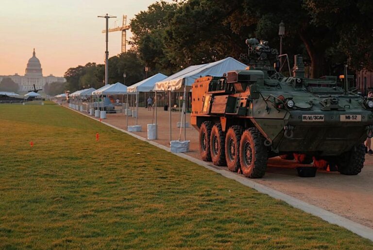 Large outdoor event with a security vehicle and several tents being set up for a public event, showcasing safety and event organization.