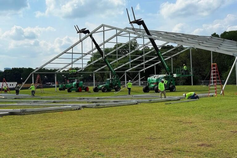 Outdoor event setup featuring a frame tent with party rental tables and chairs, ready for a celebration with friends and family.