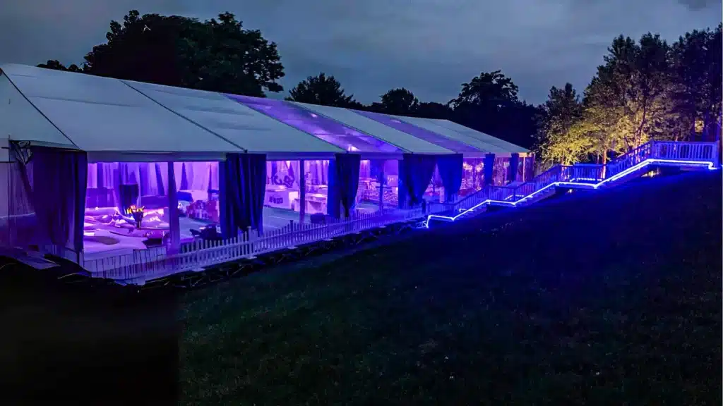Stunning Party Tent Rentals illuminated with vibrant purple lighting, perfect for creating an elegant atmosphere at your next event.