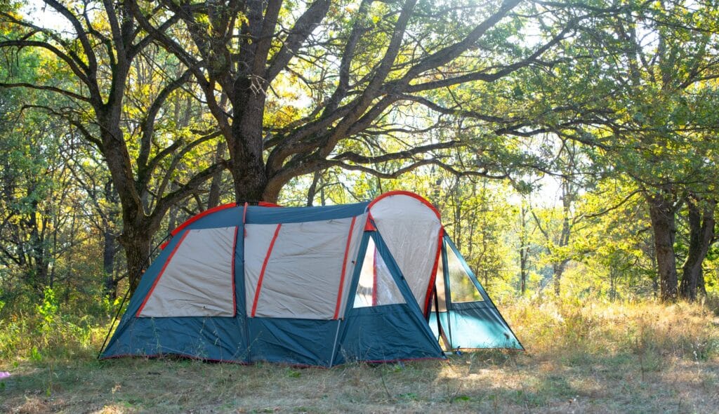 Coleman tent set up in a serene forest, offering comfort and shelter for camping adventures.