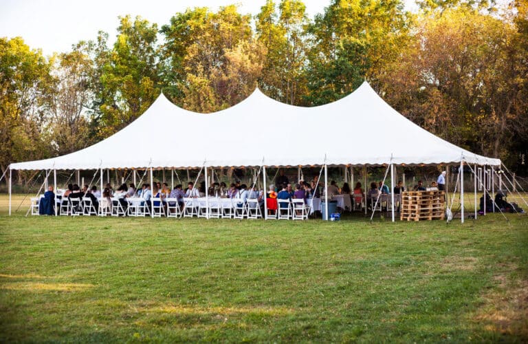 Outdoor tent rental set up for a large event, offering shelter and comfort for guests.