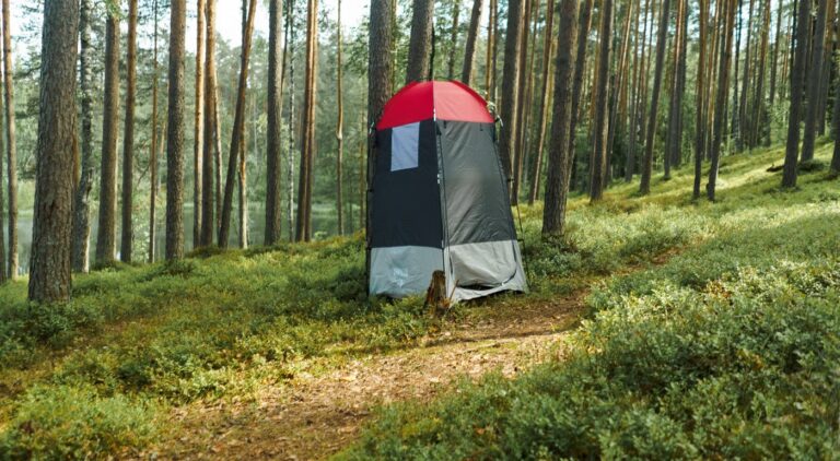 Shower tent set up in the forest, providing outdoor privacy and convenience for campers.