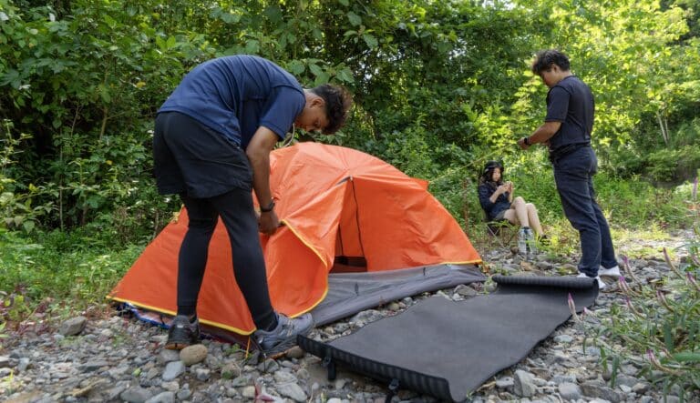 Stretcher tent being set up in the wilderness, providing quick and convenient outdoor shelter.