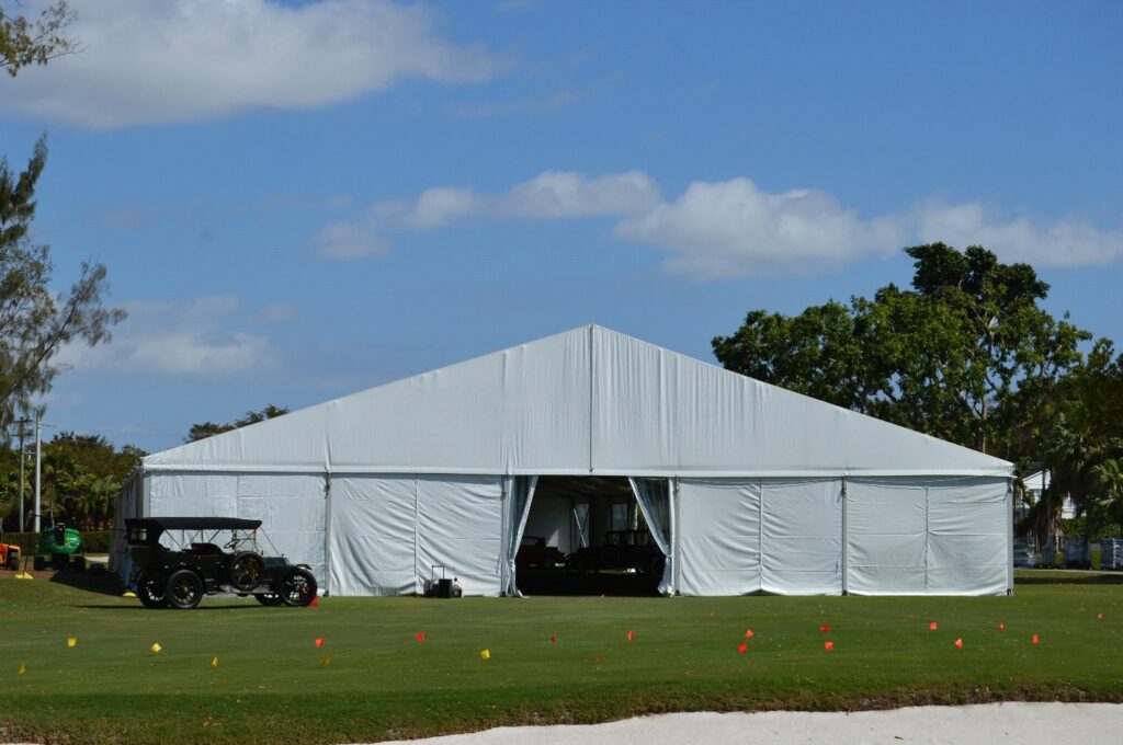 Large white industrial-grade structure tents for storage set up on a field, providing weather-resistant space for inventory.
