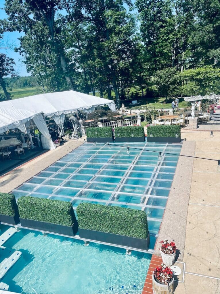 Clear glass pool covers installed over an outdoor swimming pool to create a walkable event floor and dance area.
