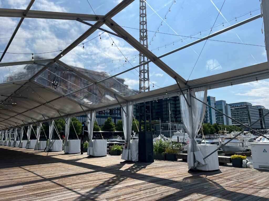 Clear Top or White Top Tent event setup with transparent roof and outdoor waterfront view.